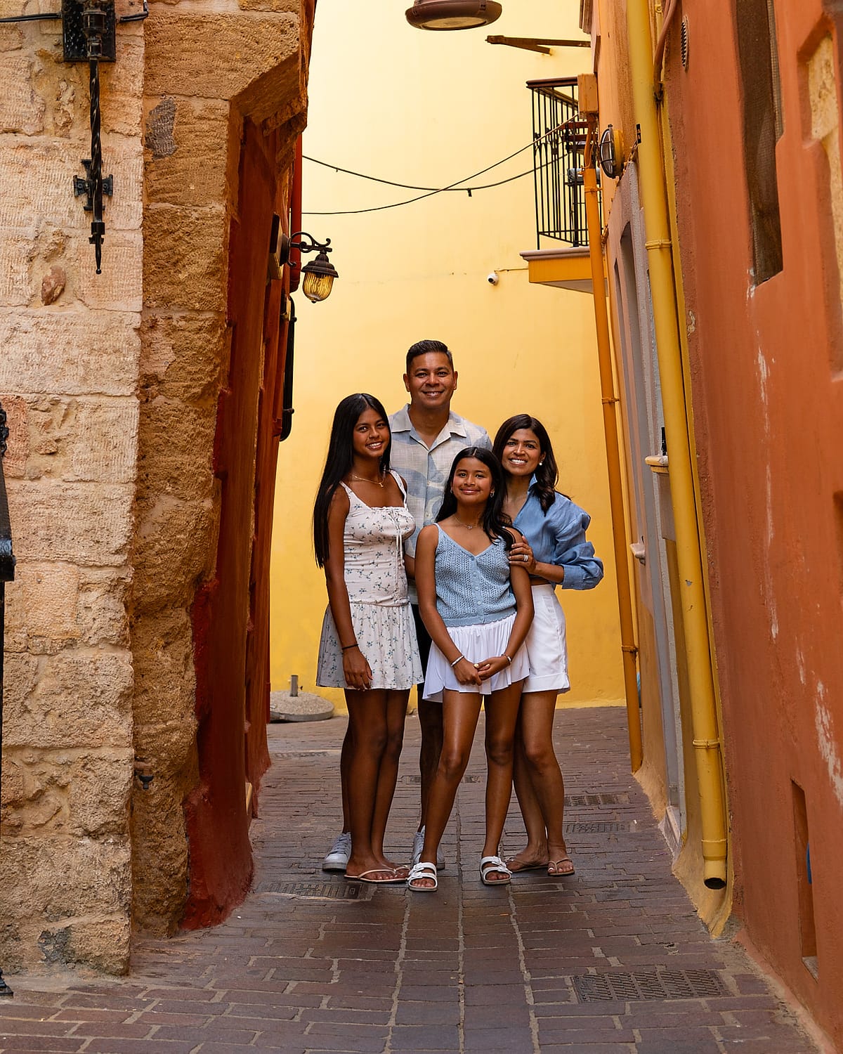 Family of four photographed in a sunlit Chania Old Town alley