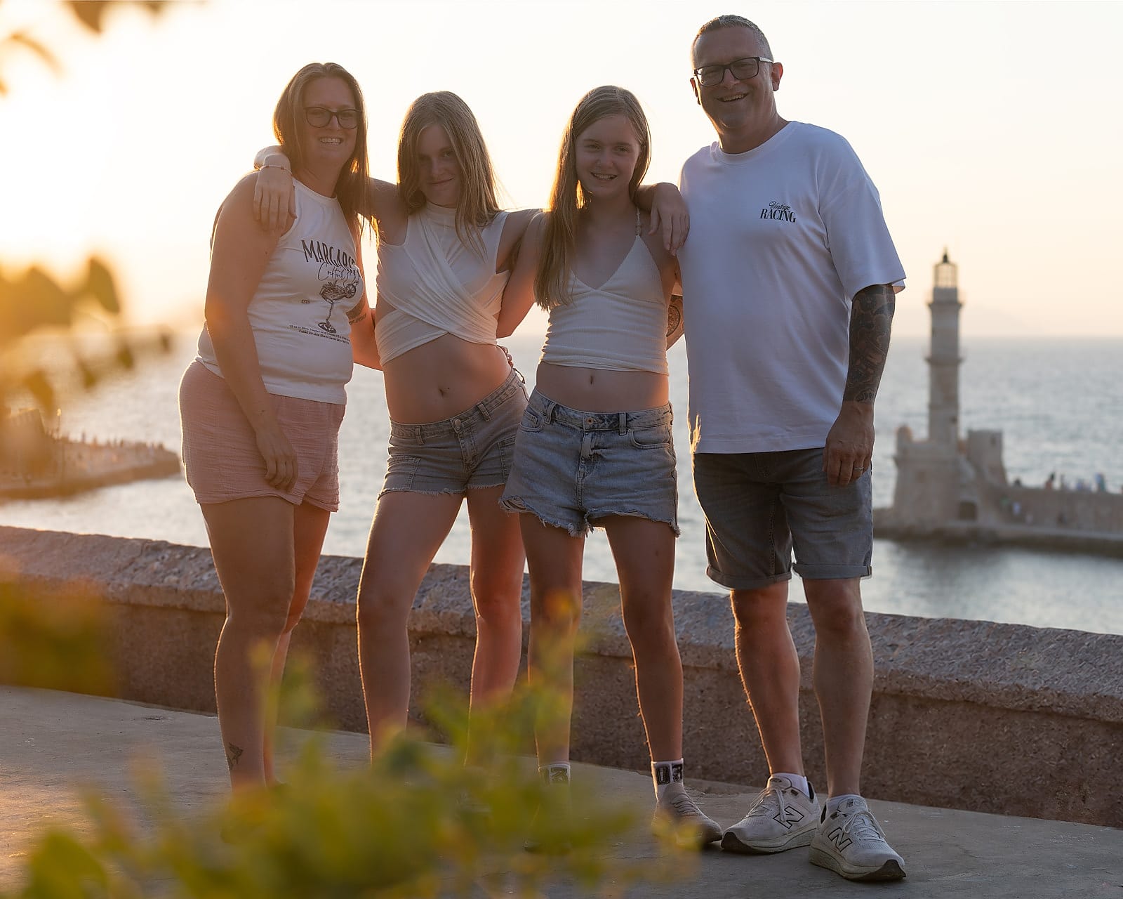 Family group photographed at sunset by the Venetian Harbour lighthouse in Chania