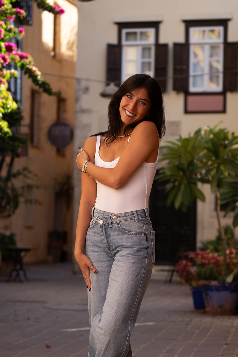Young woman photographed in a Chania Old Town square with bougainvillea and shuttered windows